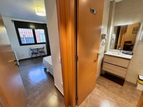 a small bathroom with a sink and a mirror at MT Boutique Suites y Apartamentos - Adults Only - in Mataró