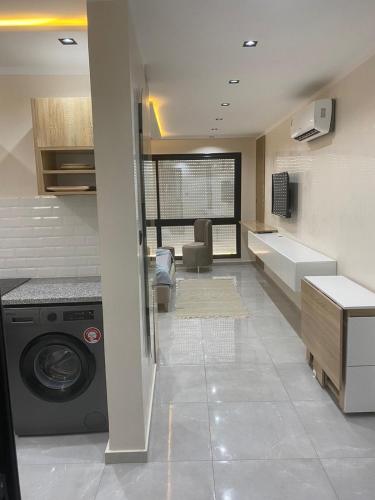 a kitchen with a washing machine in a room at Tokyo in Akouda