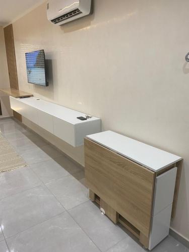 a bathroom with a bench and a tv on a wall at Tokyo in Akouda