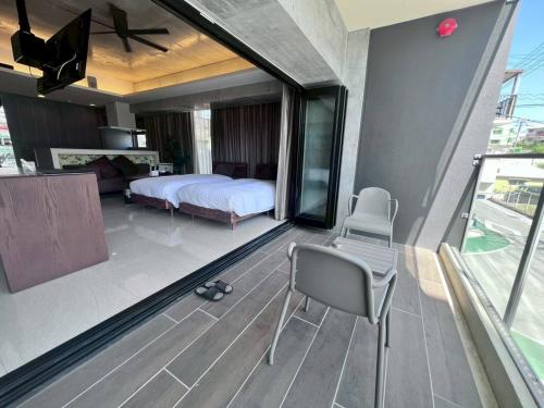 a bedroom with a bed and a balcony at HOTEL Viviana in Naha
