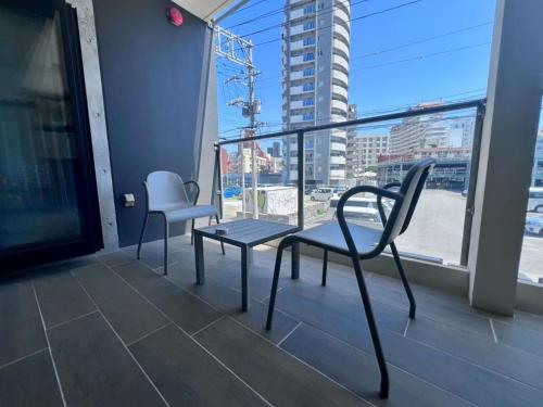 a balcony with two chairs and a bench and a window at HOTEL Viviana in Naha