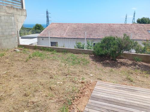 a yard with a fence and a house at Haute-Corse Bas de villa , 2 chambres de 70 m2 , vue mer , jardin et terrasse in Furiani