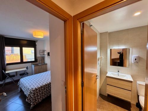 a bathroom with a bed and a sink in a room at MT Boutique Suites y Apartamentos - Adults Only - in Mataró