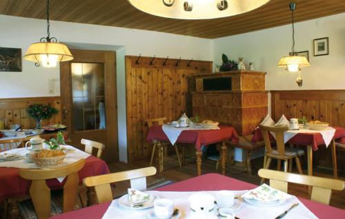 ein Restaurant mit Tischen, Stühlen und roten Tischdecken in der Unterkunft Klausenhof in Pertisau