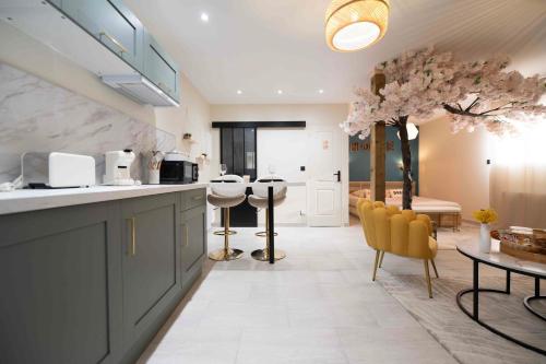 une cuisine avec un comptoir, des chaises et une table dans l'établissement Nid d'amour, à Cristot