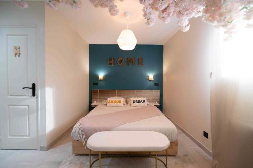 - une chambre dotée d'un lit et d'une enseigne sur le mur dans l'établissement Nid d'amour, à Cristot