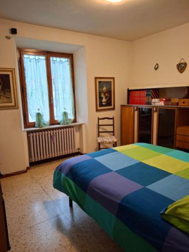 a bedroom with a colorful bed and a window at Casotti in Cutigliano