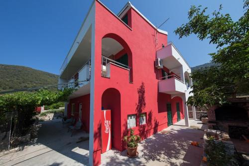 a red building with a large letter on the side at Ground floor apartment in Razvala