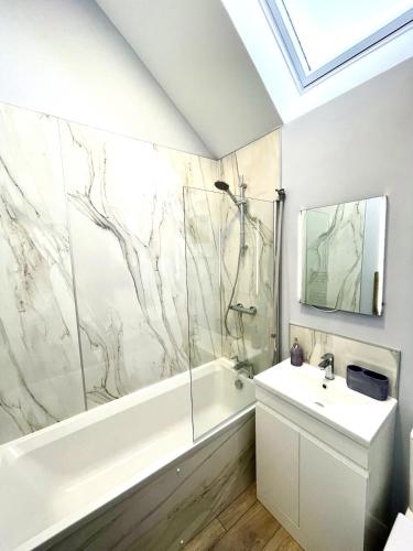 a bathroom with a shower and a tub and a sink at Rose Wynd Cottage-Close to beach in Crail