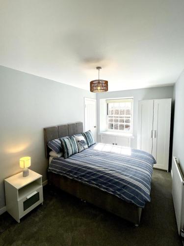 a bedroom with a bed and a window at Rose Wynd Cottage-Close to beach in Crail