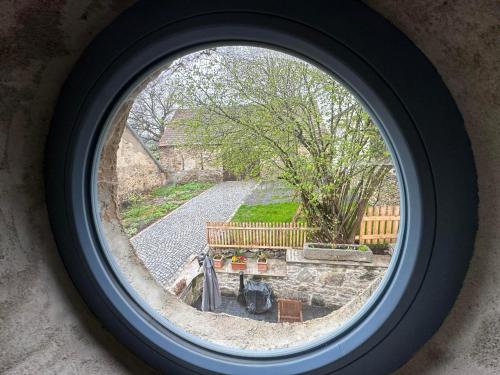 a round window with a view of a garden at Chalupy Albrechtice Šumava in Sušice