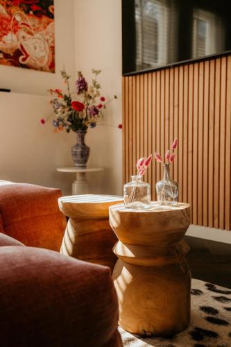 a living room with a table with vases on it at Slapen aan Zee in Vlissingen