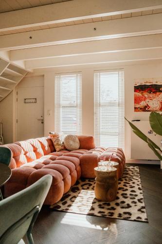 a living room with a large couch and chairs at Slapen aan Zee in Vlissingen
