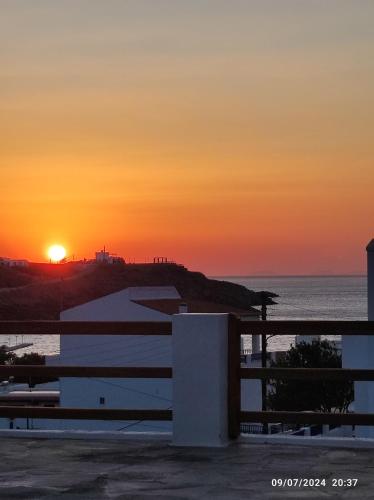 a sunset over the ocean with a white building at The View House 2 in Kithnos