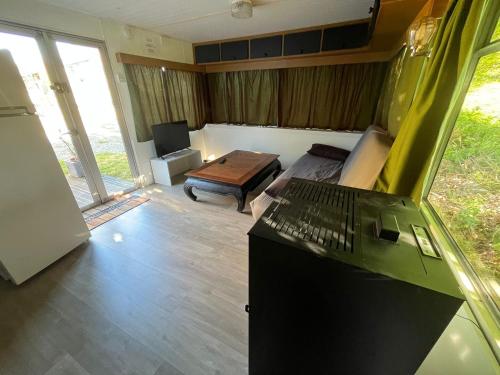 a living room with a couch and a desk with a laptop at Gite "home" - piscine in Juvigny-le-Tertre