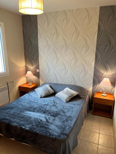 - une chambre avec un lit bleu et 2 tables de chevet dans l'établissement Les Pieux -6km de la mer, à Grosville