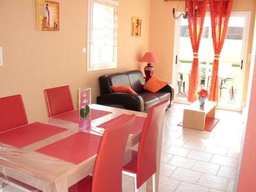 - un salon avec une table et un fauteuil en cuir dans l'établissement Les Pieux -6km de la mer, à Grosville