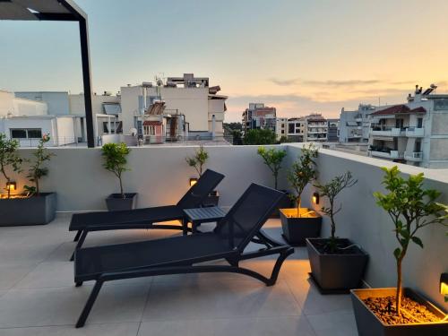 a balcony with two chairs and a view of a city at 10 Apartments & Suites Athens in Athens