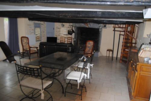 une salle à manger avec une table et des chaises et une cheminée dans l'établissement maison de campagne, à La Celle-sous-Gouzon