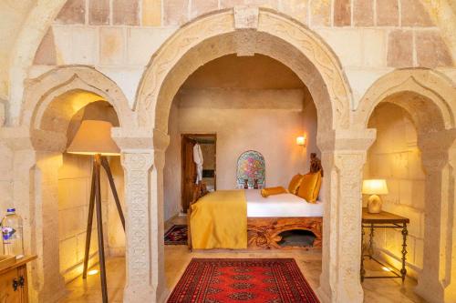 a bedroom with a bed in a stone wall at Onur Cave Cappadocia in Goreme