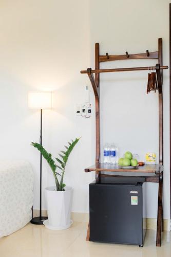 a table with a plate of fruit and a plant at Green homestay, Huế in Hue