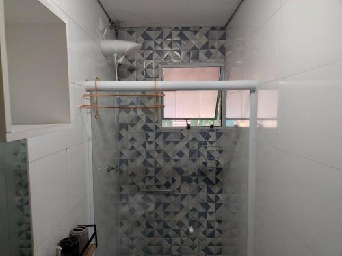un bagno con doccia con porta in vetro di Casa com piscina privativa a Bertioga