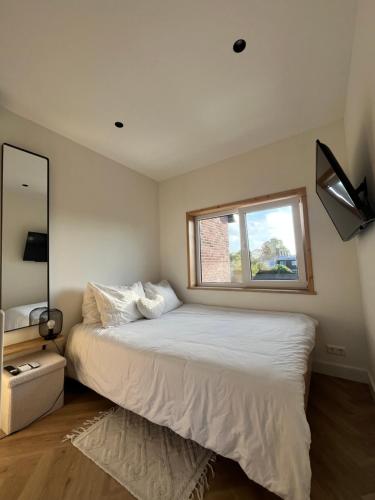 アールスメールにあるTiny House in center Aalsmeer I Close to Schiphol & Amsterdamの窓のある白いベッドのある寝室