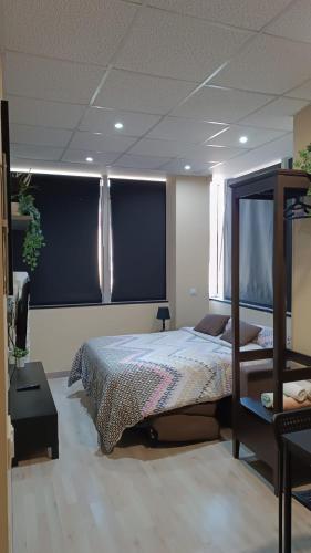 a bedroom with a bed and a large window at Estudios 85 - Cerca de Madrid, Toledo y Parque Warner in Parla