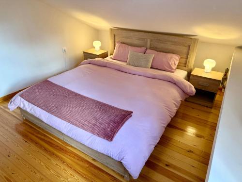 a bedroom with a large bed with pink sheets and pillows at Nea Makri Holiday Villa in Nea Makri