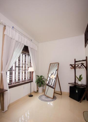 a room with a mirror and a window at Green homestay, Huế in Hue
