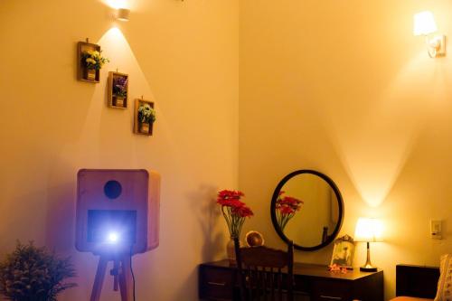 a room with a lamp and a mirror and a light at Green homestay, Huế in Hue