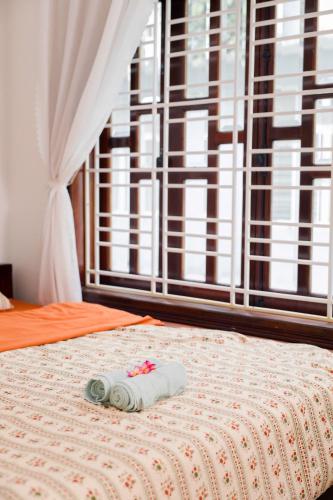 a bed with a towel on it with a window at Green homestay, Huế in Hue