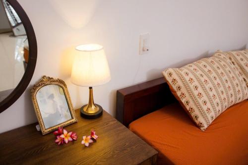 a bed room with a table with a mirror and a lamp at Green homestay, Huế in Hue