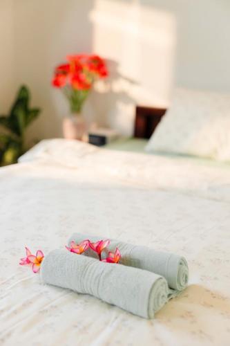a rolled up towel on a bed with flowers on it at Green homestay, Huế in Hue