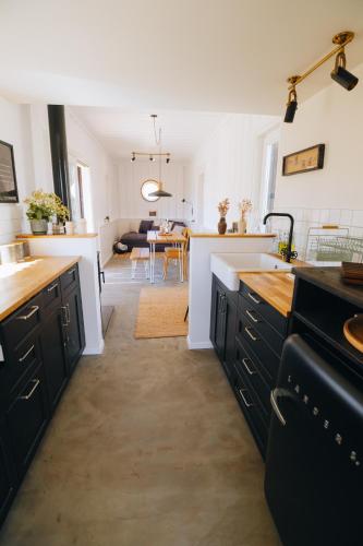 a kitchen with black cabinets and a living room at הפטריוטית-יקב ננה in Mitzpe Ramon