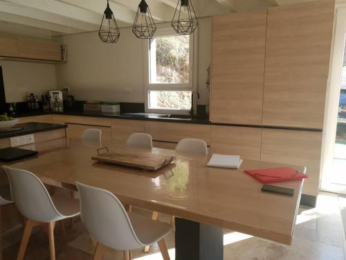une cuisine avec une grande table et des chaises en bois dans l'établissement Chalet rénové, 4 chambres, quartier calme, parking - FR-1-234-292, à Cauterets