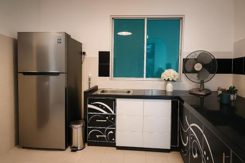 eine Küche mit Kühlschrank und Spüle in der Unterkunft 4BR Near SPICE Arena Free Parking in Bayan Lepas