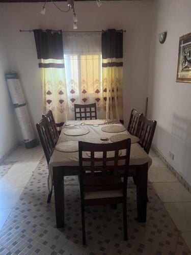 a dining room with a table and four chairs at Busumbala 88HP 326 Gambia in Busumbala