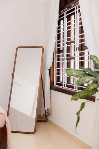 a mirror in a room next to a window at Green homestay, Huế in Hue