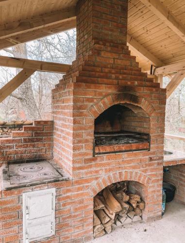 a brick oven with a pile of fire wood at Căbănuțele de lângă râu in Păucineşti