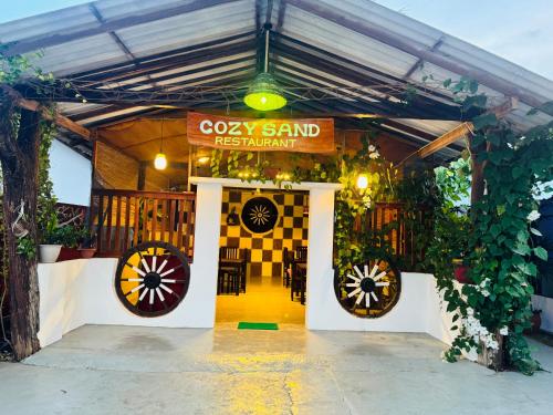 a restaurant with two large wheels and a sign at Cozy Sand Beach Hotel in Arugam Bay