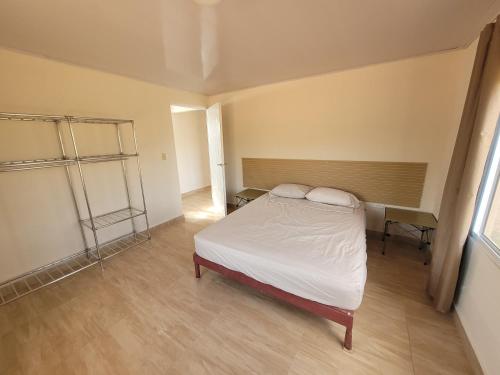 een kleine slaapkamer met een bed en een bureau bij Casa de Campo, Olá, ríos, cascadas, Los Picachos in Olá