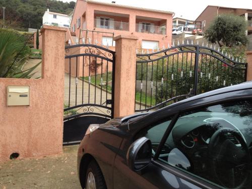 une voiture garée devant un portail noir dans l'établissement Haute-Corse Bas de villa , 2 chambres de 70 m2 , vue mer , jardin et terrasse, à Furiani