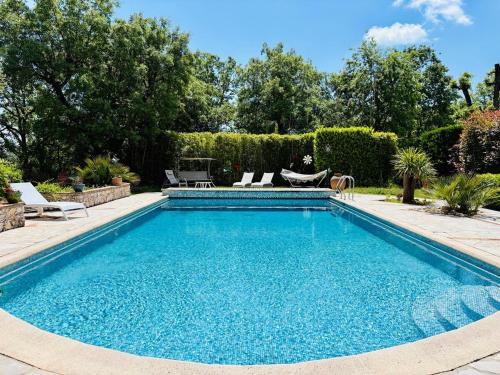une piscine avec de l'eau bleue dans une cour dans l'établissement Hacienda Provençale- Piscine, Pétanque et Plenitude, à Saint-Jeannet