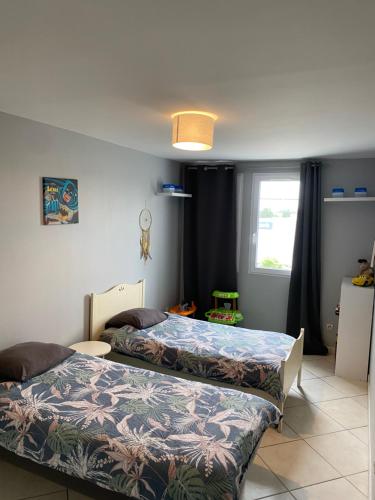 une chambre avec deux lits et une fenêtre dans l'établissement Appartement proche Disney et Paris, à Saint-Thibault-des-Vignes