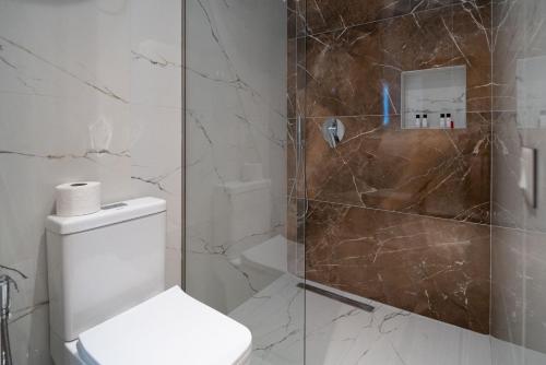 a bathroom with a toilet and a glass shower at Hotel LUMINOSA in Shkodër