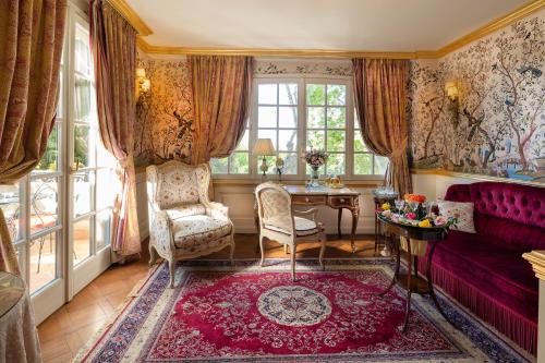 a living room with a red couch and a table at Villa Gallici Hôtel & Spa in Aix-en-Provence