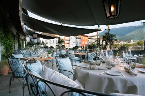 a restaurant with tables and chairs with white tablecloths at Seven Boutique Hotel in Ascona