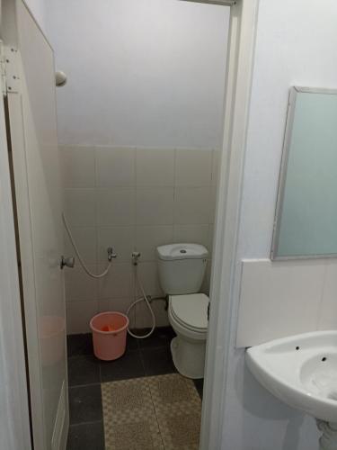 a bathroom with a toilet and a sink at Bonsai Guesthouse Banyuwangi in Banyuwangi