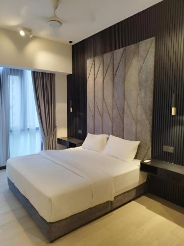 a bedroom with a large bed with a large headboard at Suites Apartment By Star Residences in Kuala Lumpur